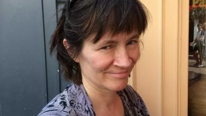 Head shot of Helen smiling with galsses on her head